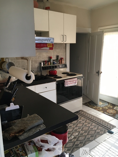 A kitchen with a black counter top and white cabinets.