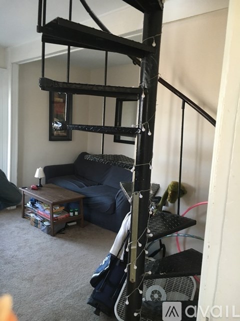 A living room with a black couch and a black shelf.