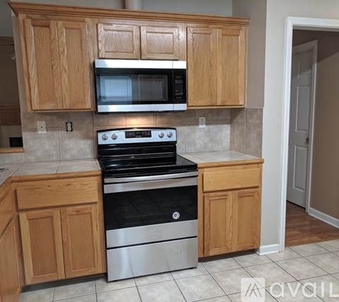 A kitchen with wooden cabinets and a stainless steel oven.
