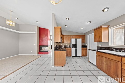 A kitchen with wooden cabinets and a tiled floor.