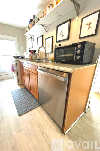 A kitchen with a black microwave on the counter.