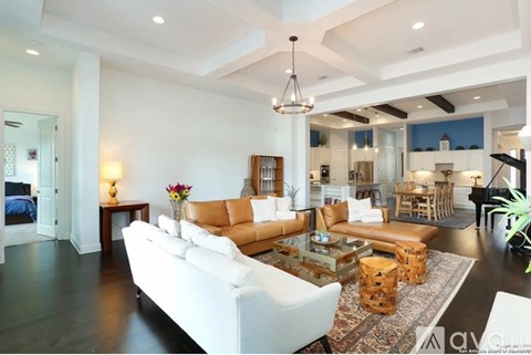 A living room with a white couch and a wooden coffee table.