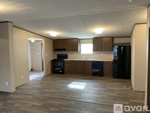 A kitchen area with wooden cabinets and black appliances.