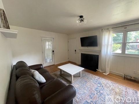 A living room with a brown couch and a white coffee table.
