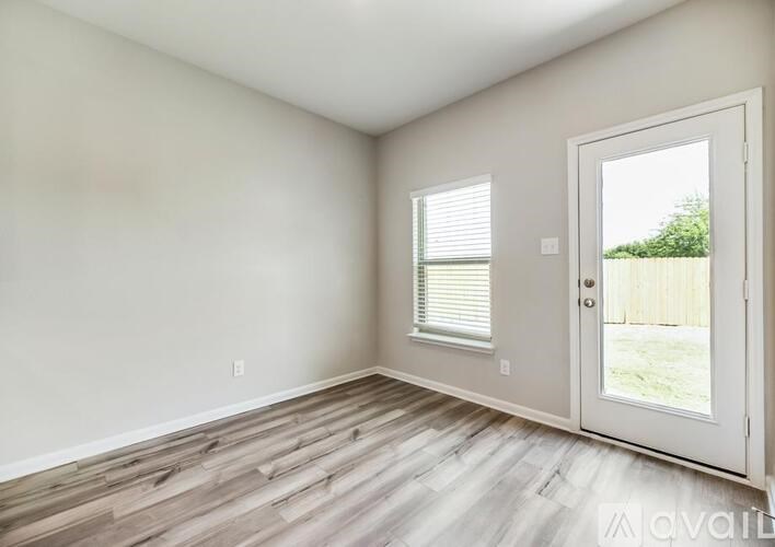 A room with a door and a window with blinds.