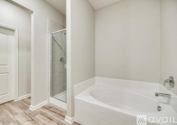 A white bathroom with a tub and shower.