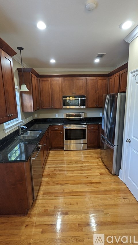 A kitchen with wooden cabinets and a black countertop.