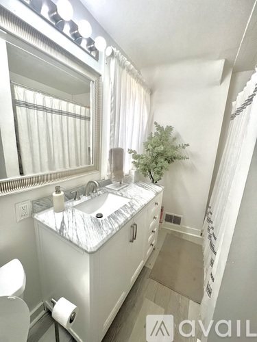 A bathroom with a sink, mirror, and toilet.