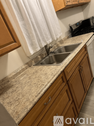 A kitchen with a sink and wooden cabinets.