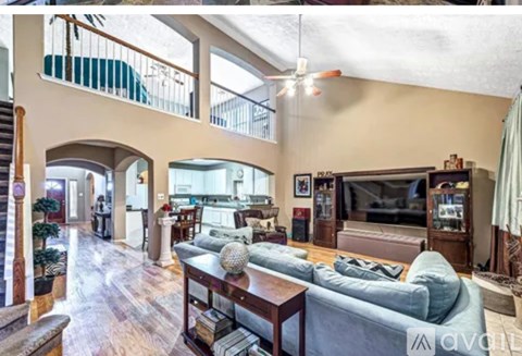 A living room with a grey couch and a television.