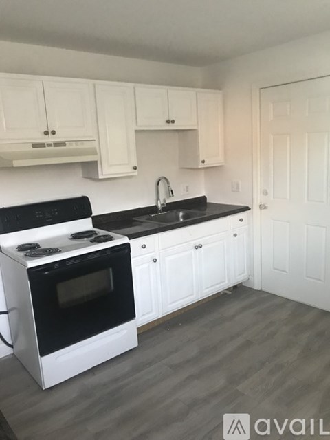 A kitchen with black countertops and white cabinets.