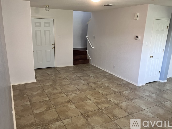 A room with beige walls and tile flooring.