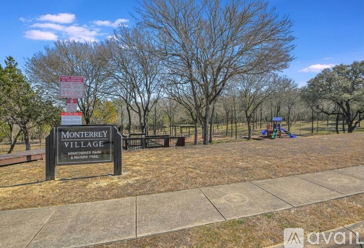 A sign for Monterrey Village is in front of a playground.