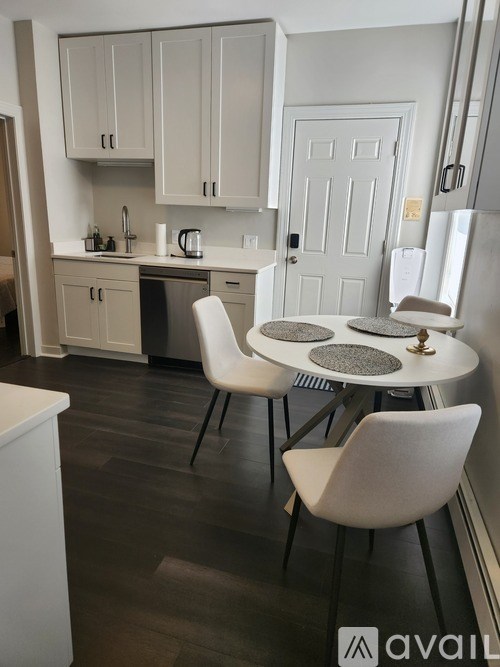 A kitchen with a table and chairs in the foreground.