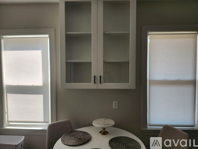 A kitchen with a table and two chairs.