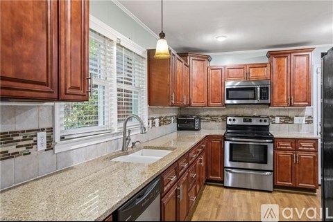 A kitchen with wooden cabinets and a granite countertop.