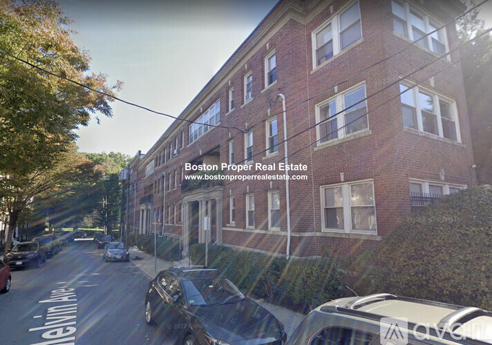 A street view of a residential area with a building that has a sign for Boston Proper Real Estate.