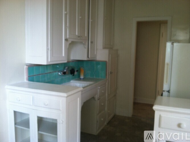 A kitchen with white cabinets and a white counter top.