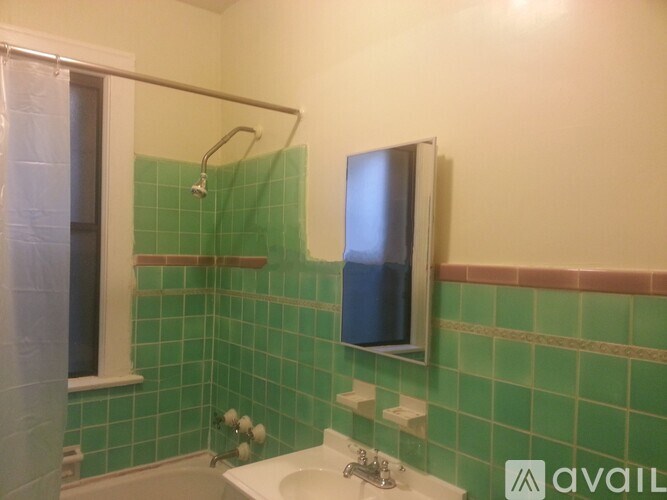 A bathroom with green tiles and a white sink.