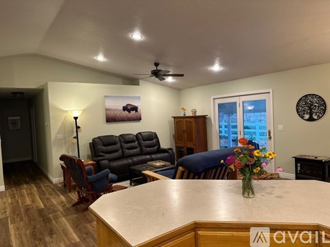 A living room with a couch, chairs, and a painting of a bison on the wall.