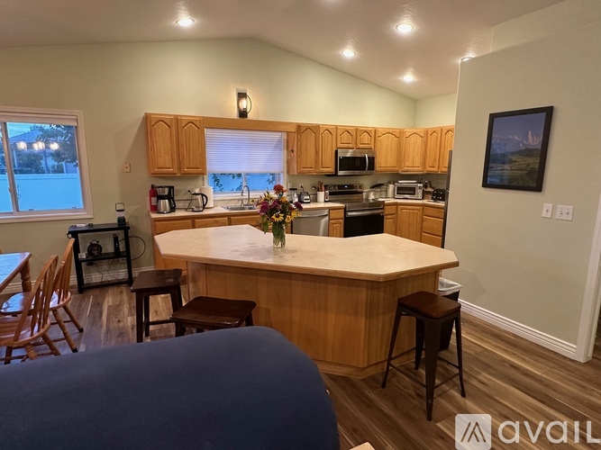 A kitchen with wooden cabinets and a large island with a vase of flowers on it.