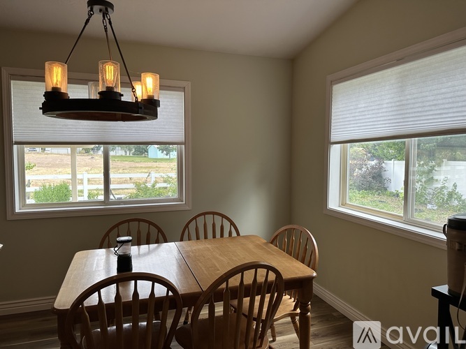 A dining room with a wooden table and chairs.