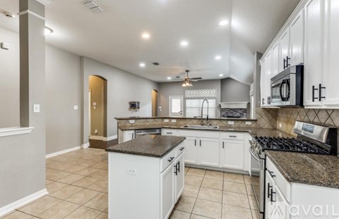 A kitchen with white cabinets and a granite countertop.