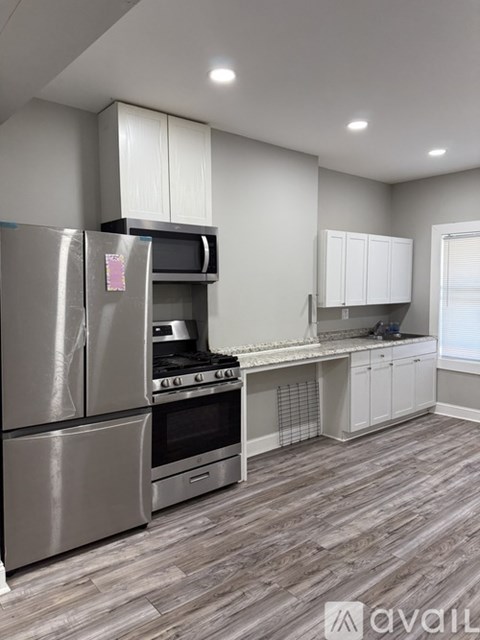 A kitchen with a stainless steel refrigerator, microwave, and oven.