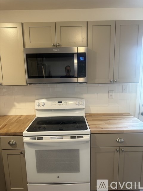 A kitchen with a white stove and a microwave above it.