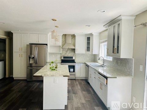 A kitchen with a marble countertop and stainless steel appliances.