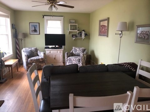 A living room with a black couch and a television.