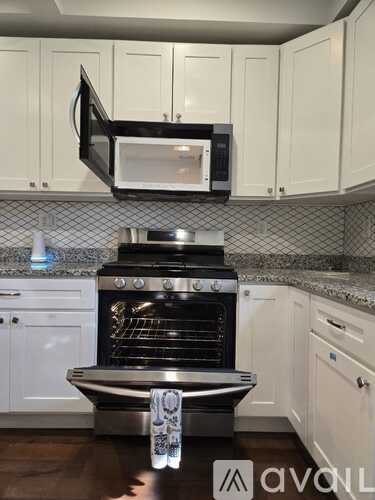A kitchen with a black oven and microwave above it.