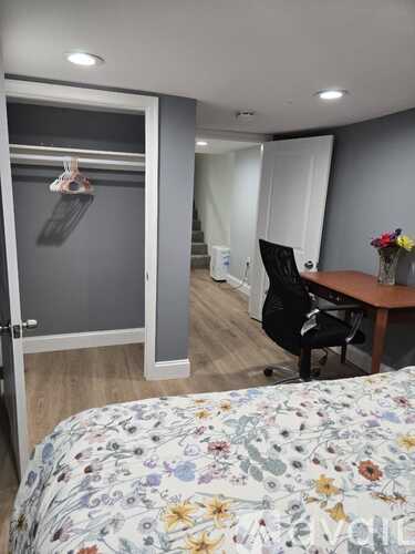 A bedroom with a floral bedspread and a desk with a chair.