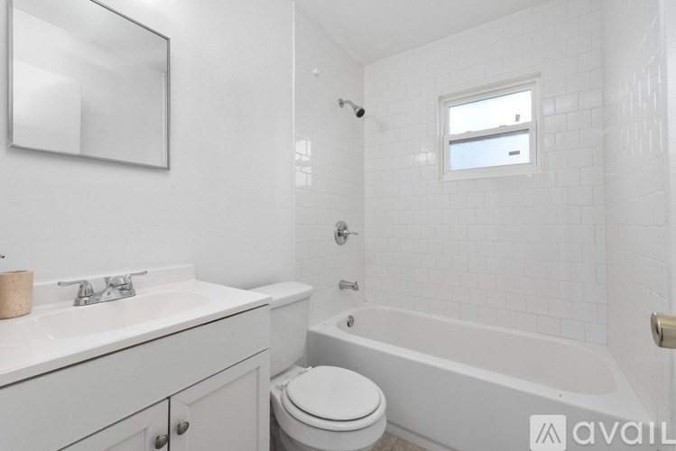 A white bathroom with a toilet, sink, and bathtub.