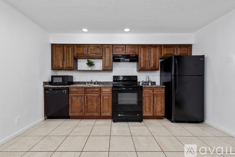 A kitchen with black appliances and wooden cabinets.