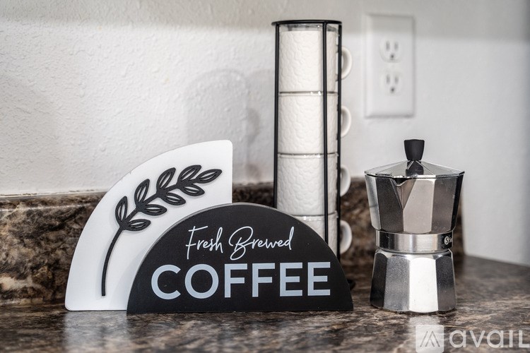 A coffee maker with a sign that says "Fresh Brewed COFFEE" is on a countertop.