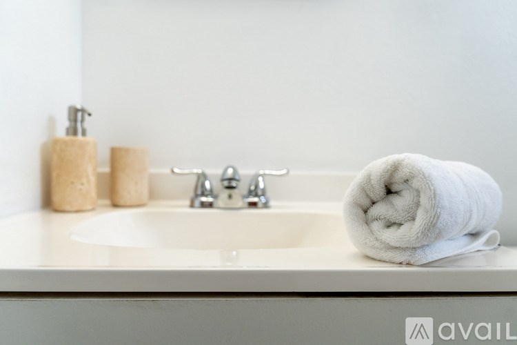 A white bathroom sink with a towel and soap dispenser.