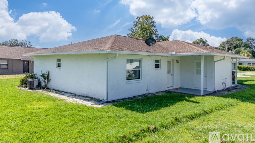 A white house with a brown roof is for sale.