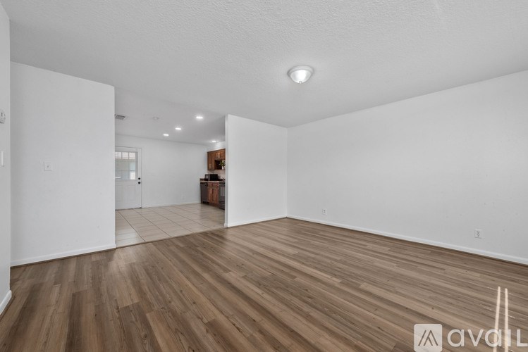 A room with wooden flooring and white walls.