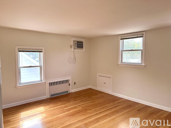 A hallway with a carpeted floor and white walls.
