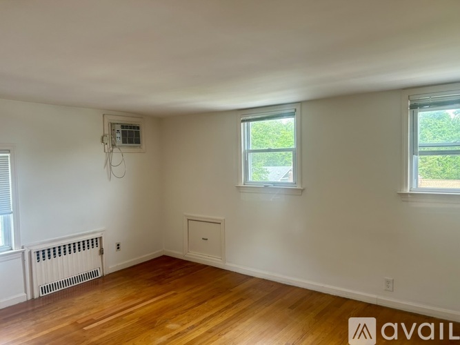 A room with wooden floors and two windows.
