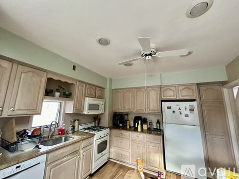 A kitchen with wooden cabinets and a white refrigerator.