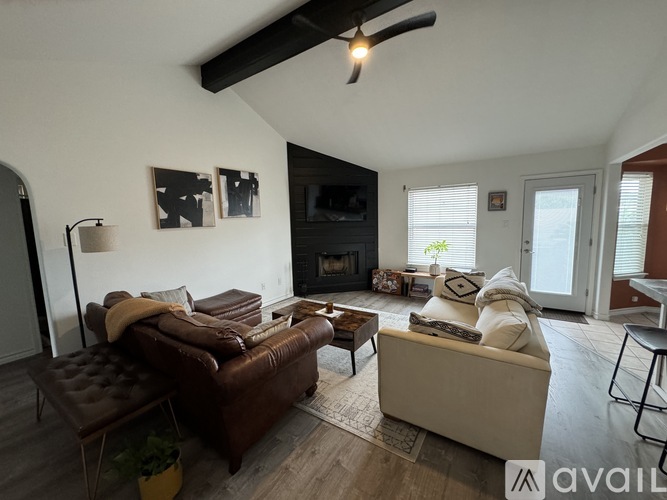 A living room with a brown leather couch and a white sofa.