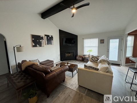 A living room with a brown leather couch and a white sofa.