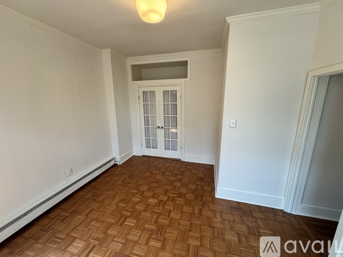 A room with a brown floor and a white door.