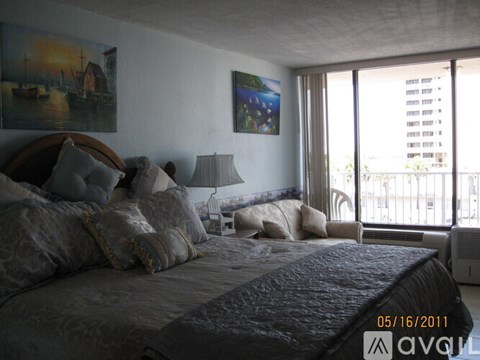 A bedroom with a large bed and a painting on the wall.