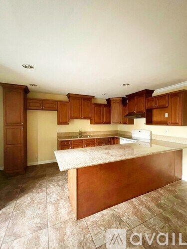 A kitchen with wooden cabinets and a marble countertop is available for rent.