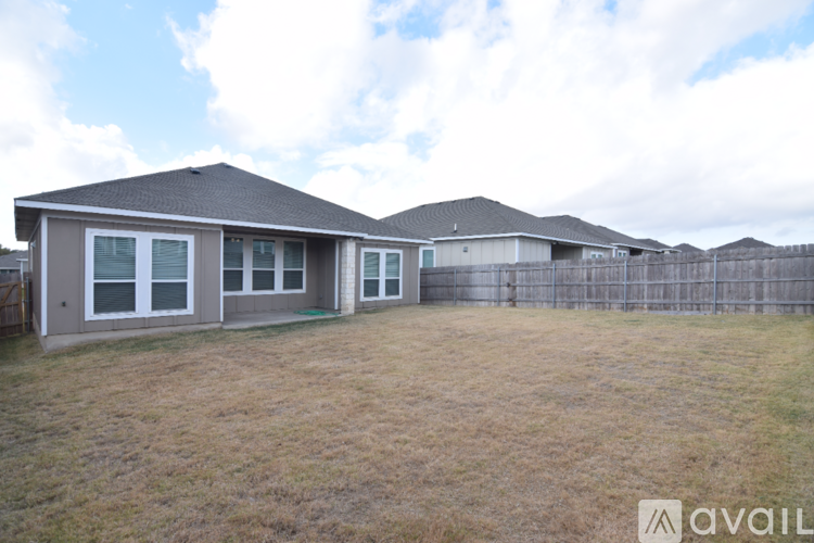 A house with a fence and a grassy yard is available for rent.
