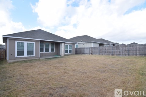 A house with a fence and a grassy yard is available for rent.