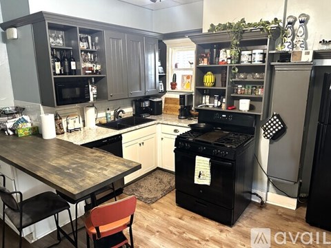 A kitchen with a black stove top oven and a black fridge.